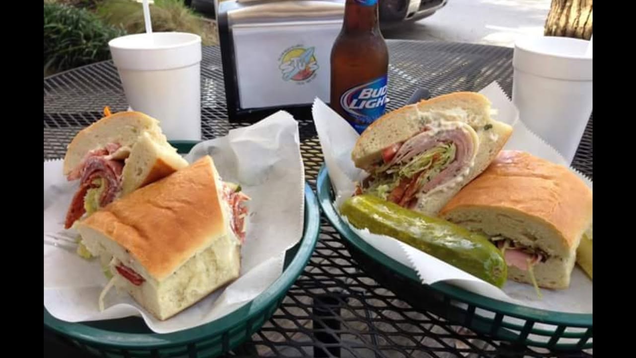 Subs and cold drinks at an outdoor table at Stus Surfside Subs